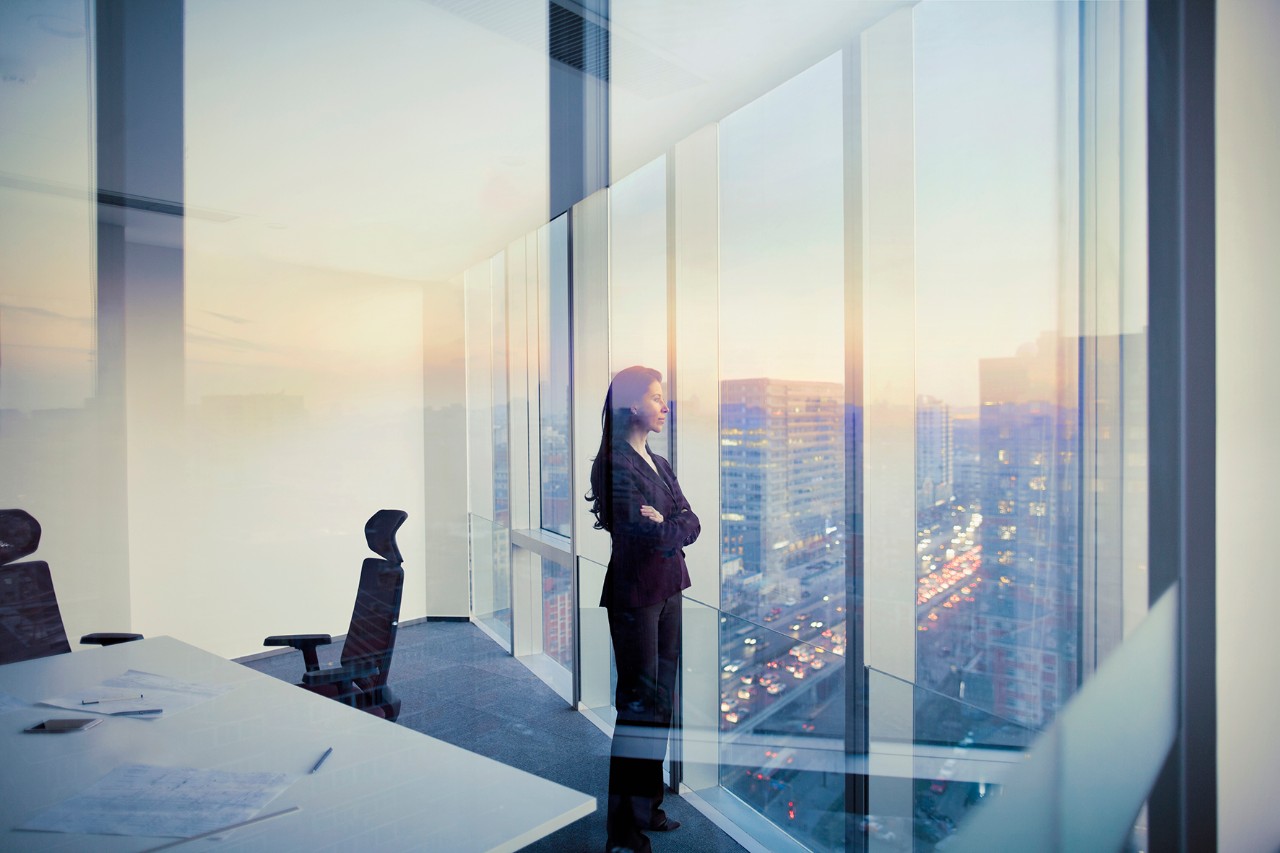 Woman looking by the window Adult Hispanic woman CEO executive businesswoman business person in conference meeting room in contemporary modern office daylight sunset dusk talking planning thinking strategy well dressed suit diversity multi-ethnic problems solutions unity cityscape downtown urban new beginnings breaking new ground decisions choices the way forward contemplation vision focus choices decisions solitude quiet alone