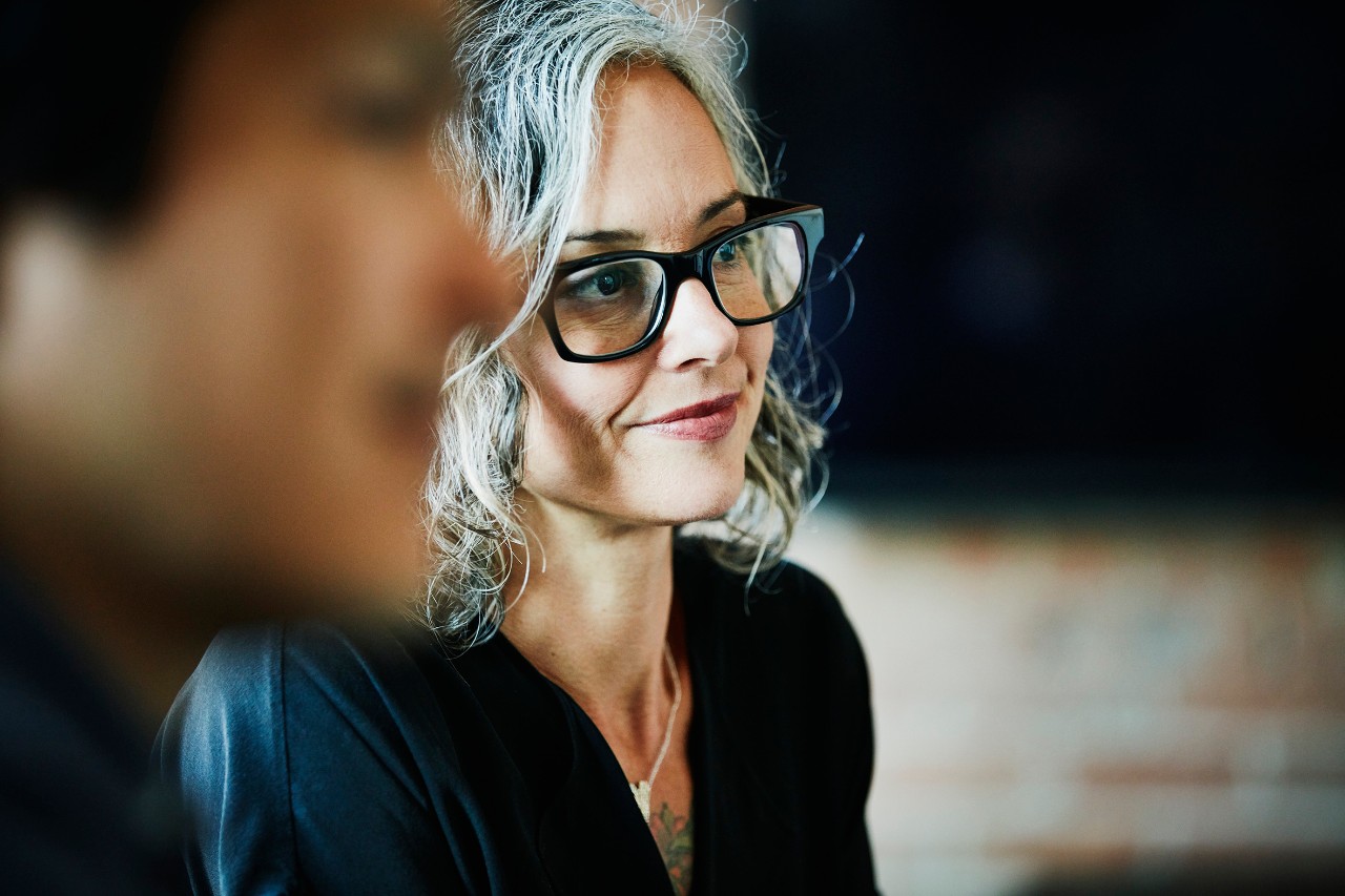 Smiling businesswoman listening during team meeting in office conference room