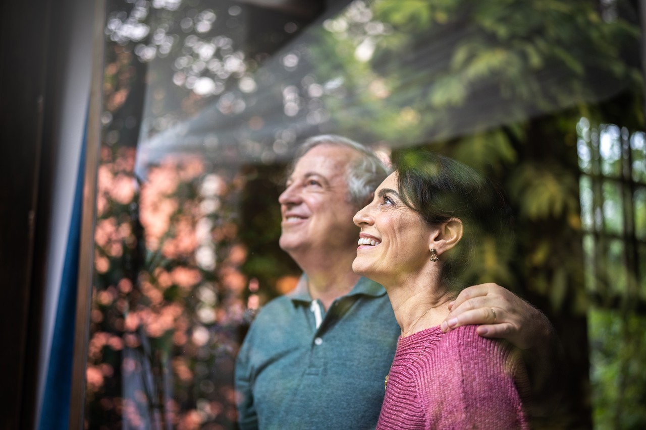 Senior couple looking through window